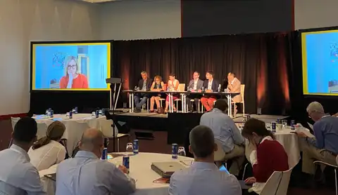 Room of people in a conference listening to a panel of speakers